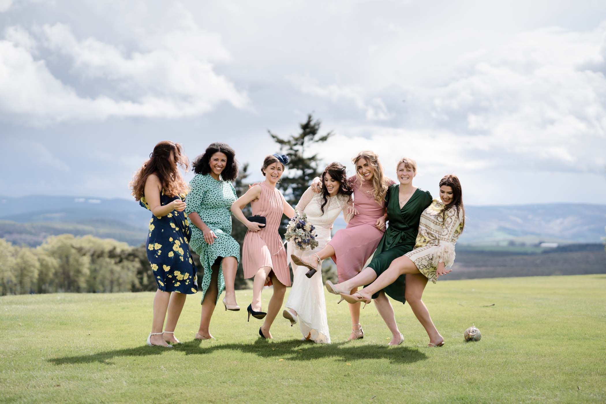 Bride and bridesmaids performing a cancan-style kick