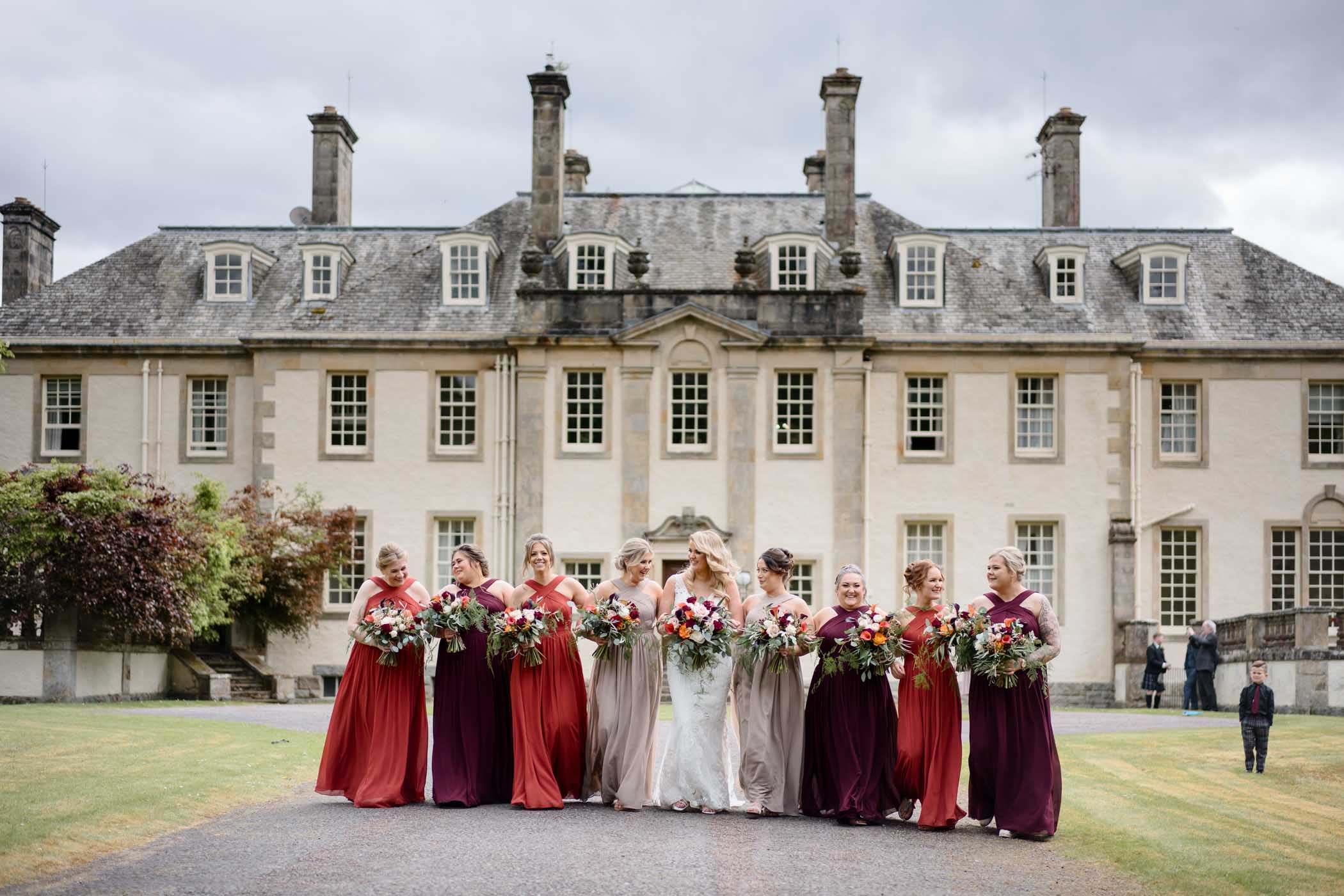 Bride and bridesmaids posing in front of Aultmore House