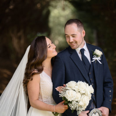Happy couple looking at each other in woodland path