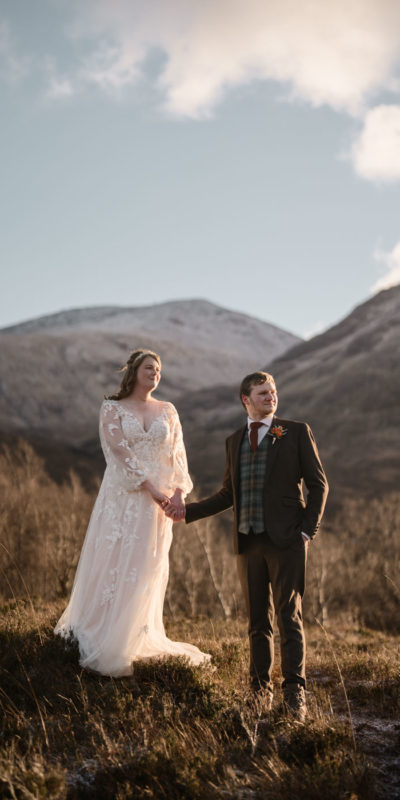 Bride and groom standing with Buachaille Etive Mòr in the background