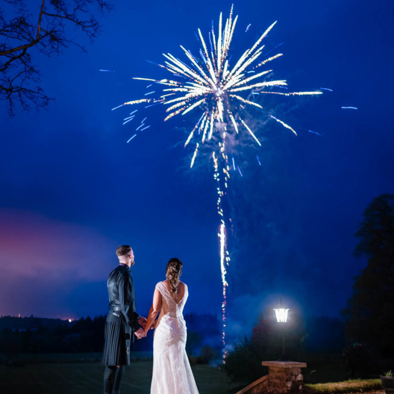Couple sharing a moment with fireworks lighting up the sky