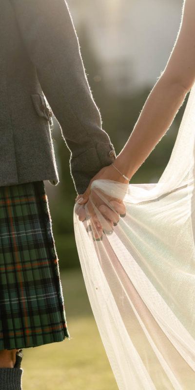 Close-up of couple holding hands during golden hour
