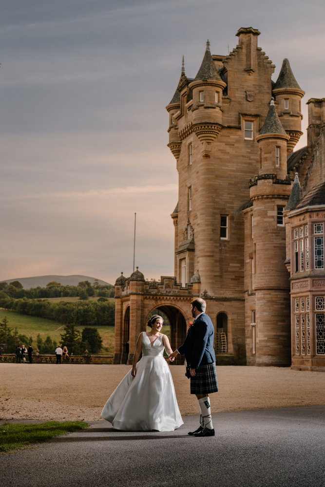 Newlyweds posing in front of the historic Ardross Castle