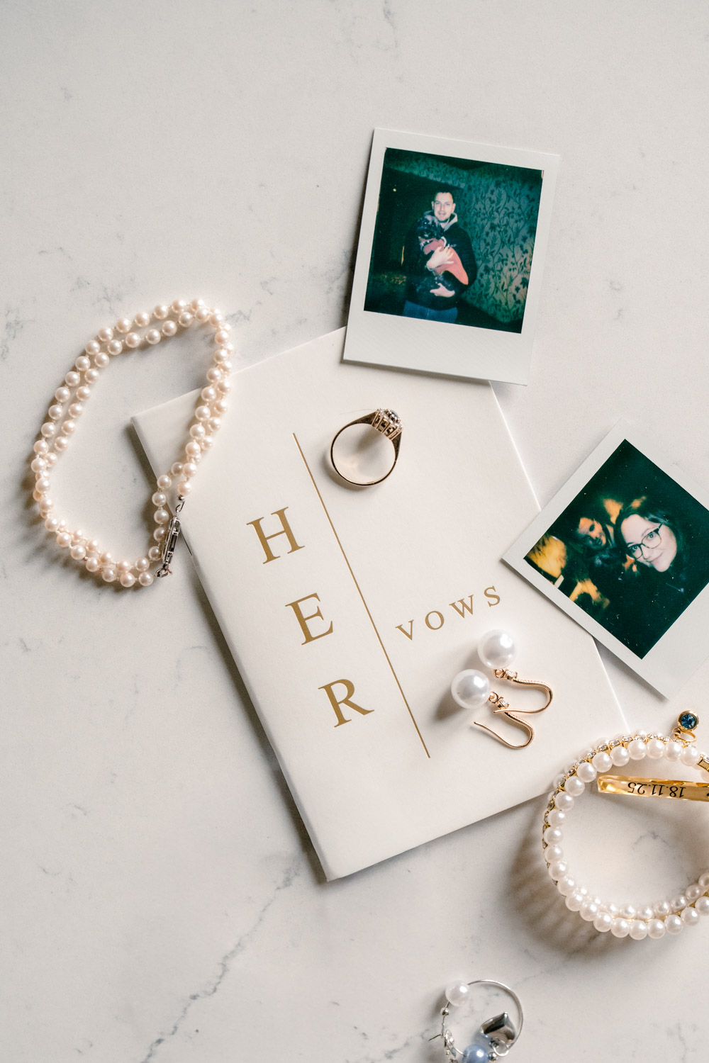 Close-up of bridal jewellery next to a vows book