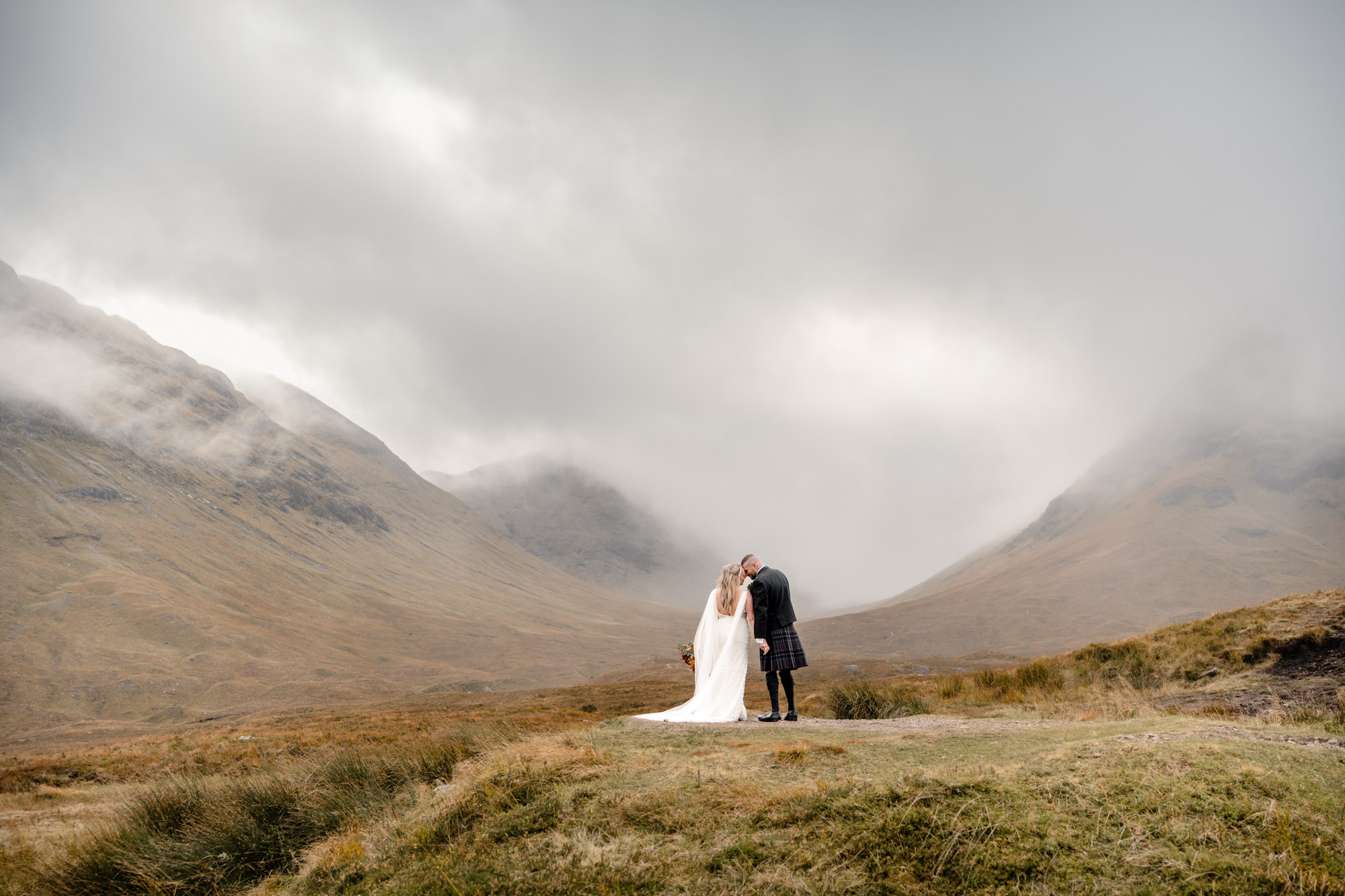 Elopement couple standing together on moorland in Glencoe