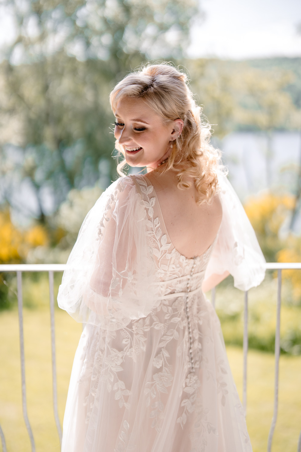 Bride glancing over her shoulder while standing on a balcony.