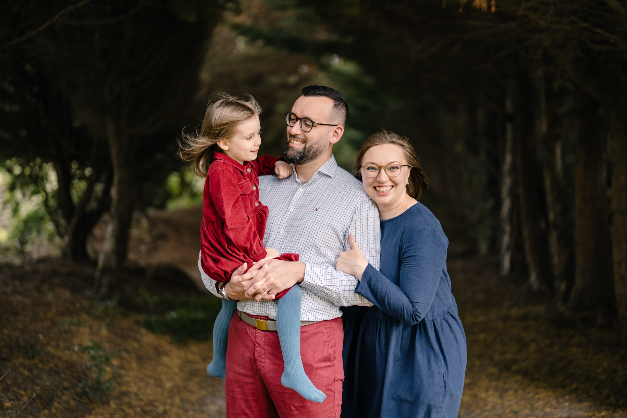 Parents and children posing on a tree-lined woodland path