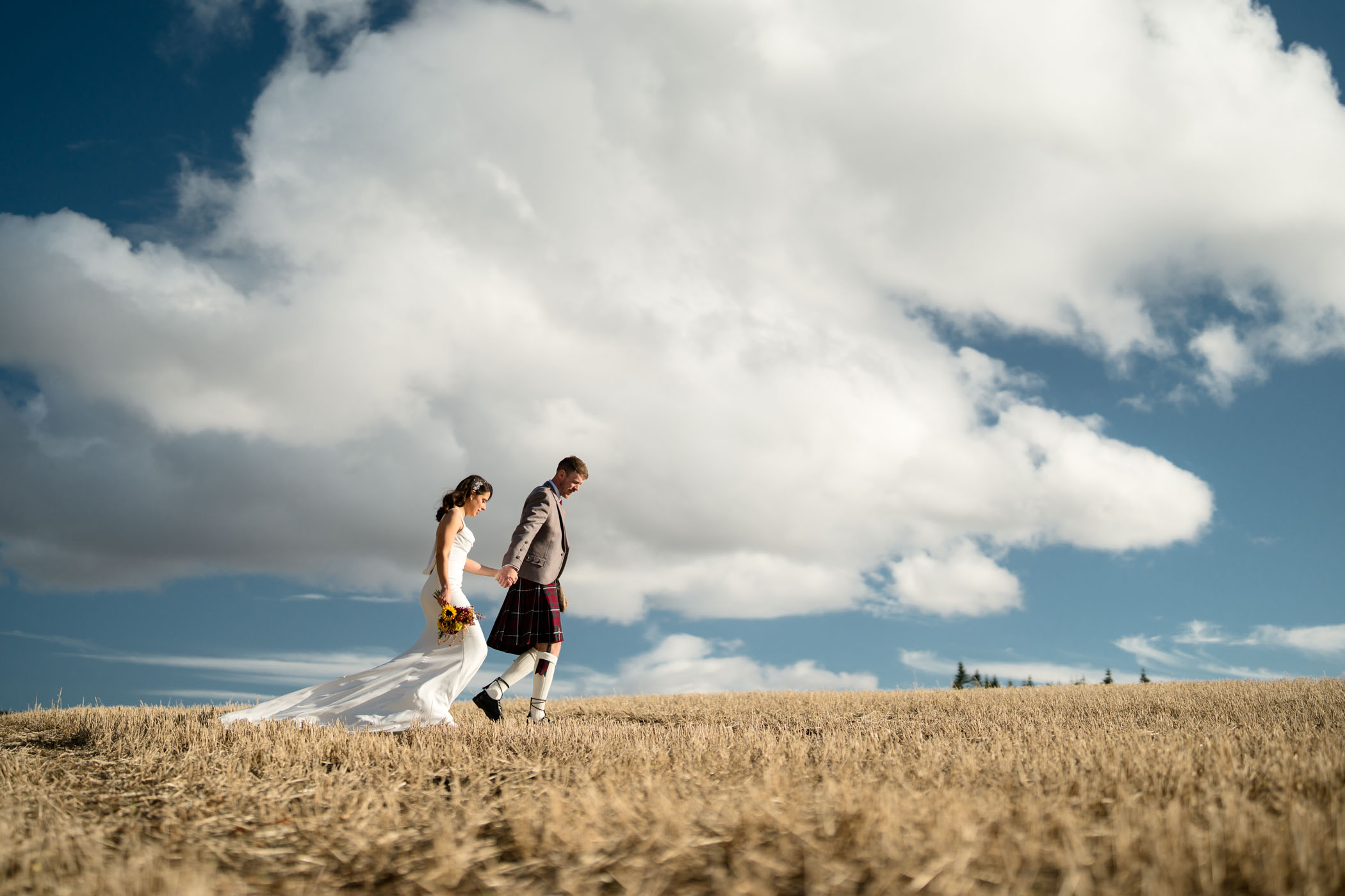 Couple strolling together through a stubble field