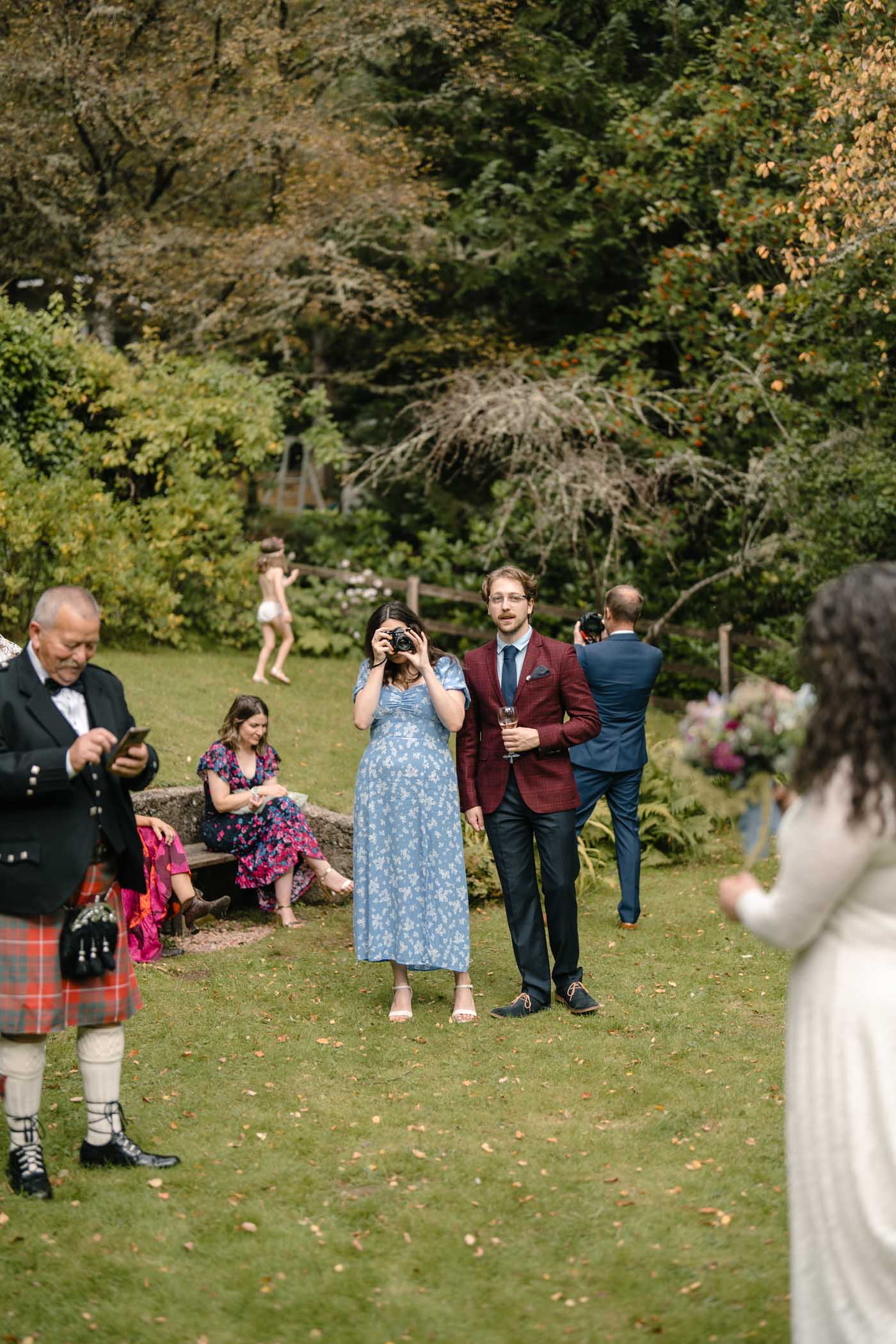 Guests capturing moments during the garden wedding reception