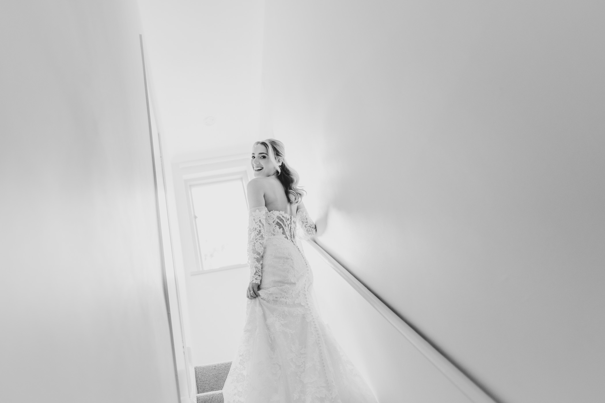 Bride ascending stairs while glancing back over her shoulder