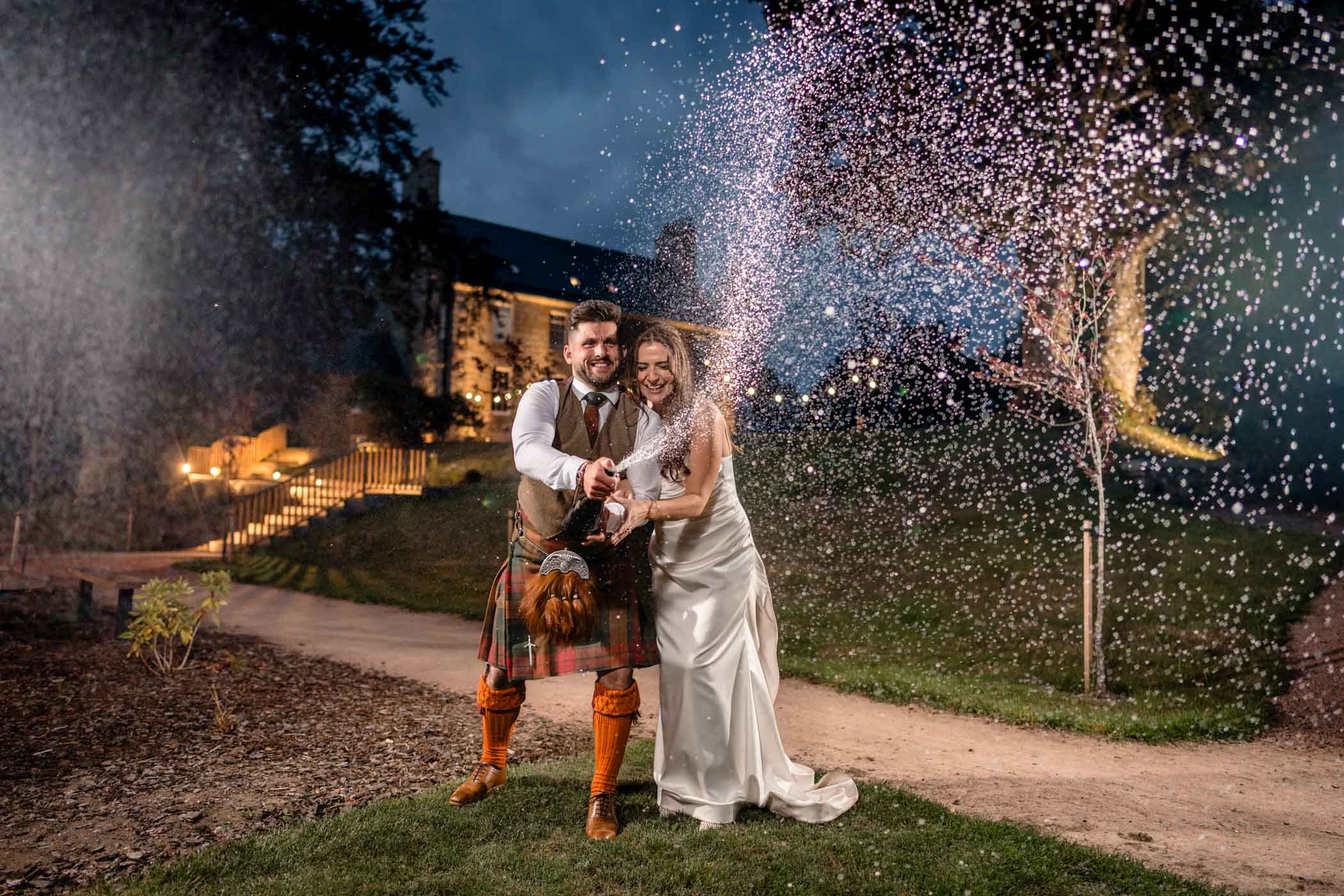Couple joyfully spraying champagne during their celebration