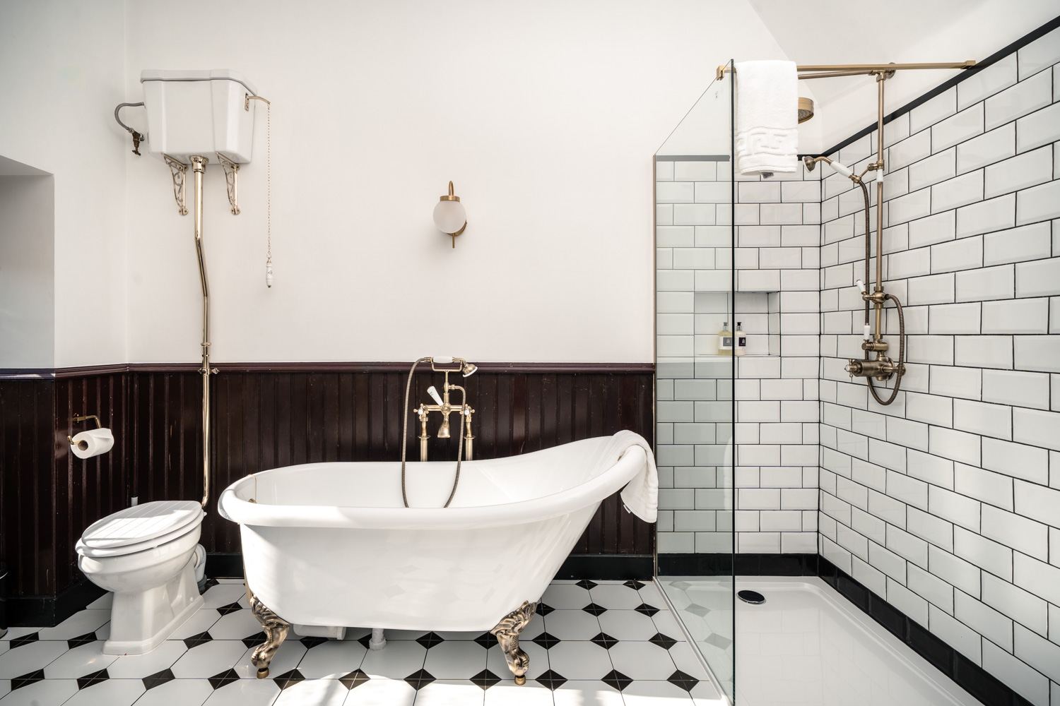 Bathroom featuring classic black and white tiled walls and flooring, creating a clean and stylish look.