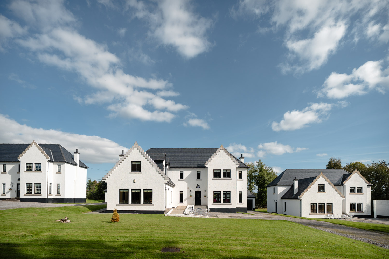Exterior view of a row of houses on a sunny day, with bright natural light highlighting the buildings and their surroundings.
