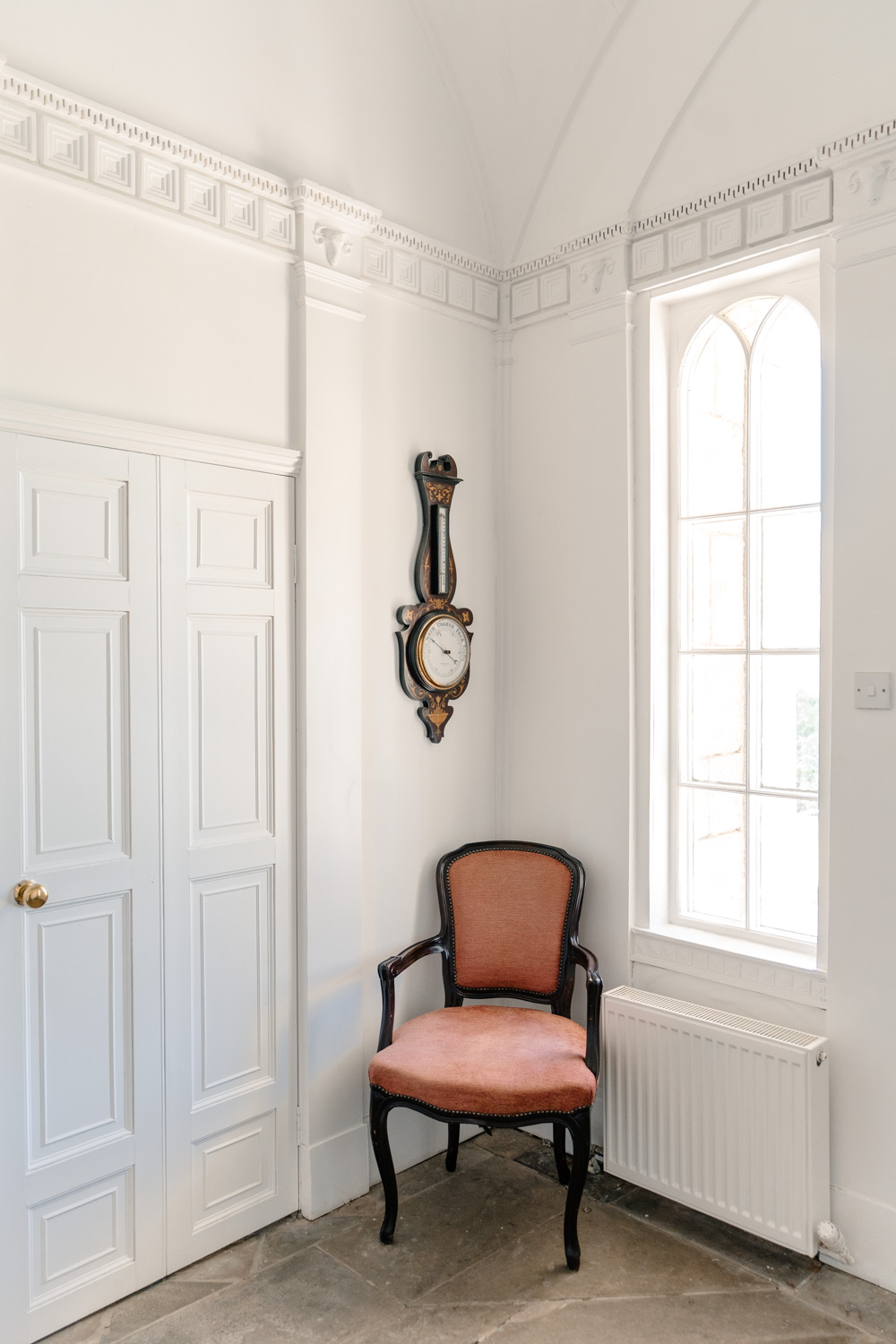 Entrance hall featuring a single chair, with period details and a welcoming atmosphere creating a sense of character and space.