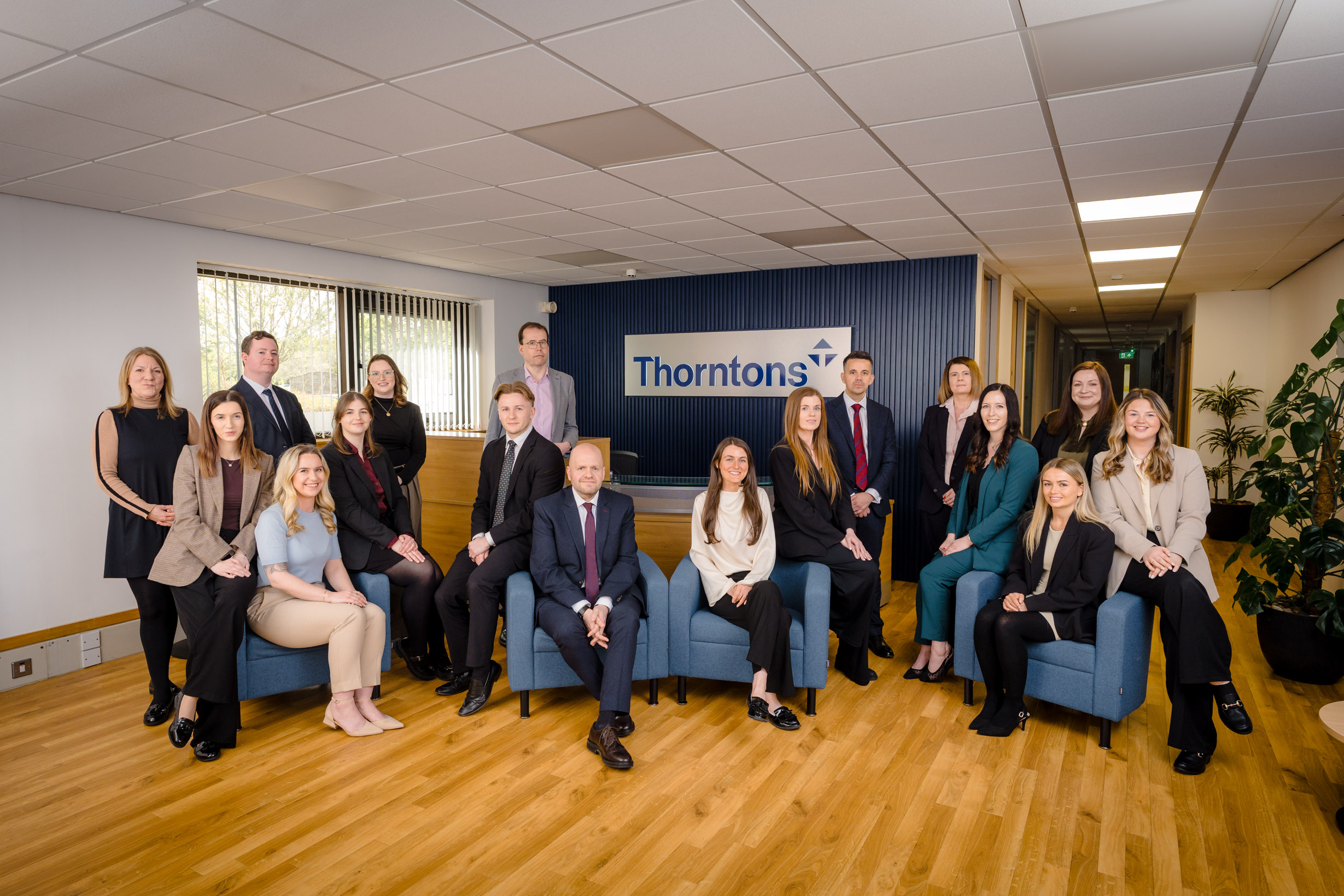 Group portrait of a team of solicitors, professionally posed together in a bright office setting.